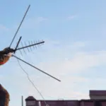 antennista su un tetto con antenna. Grazie